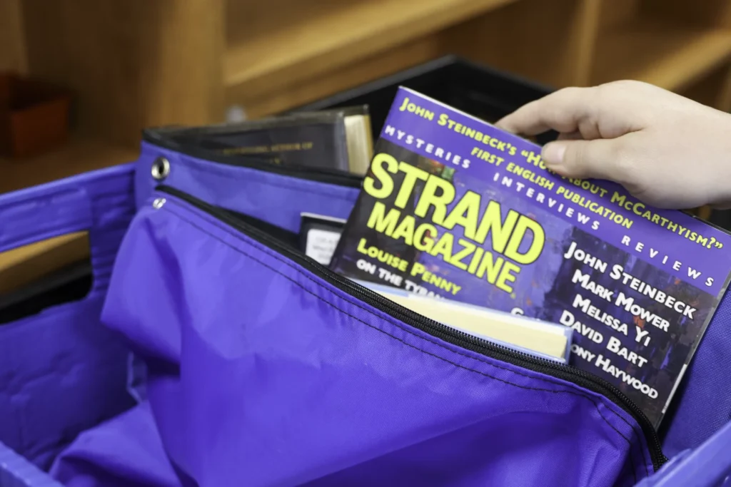 A magazine being placed inside of a bag.