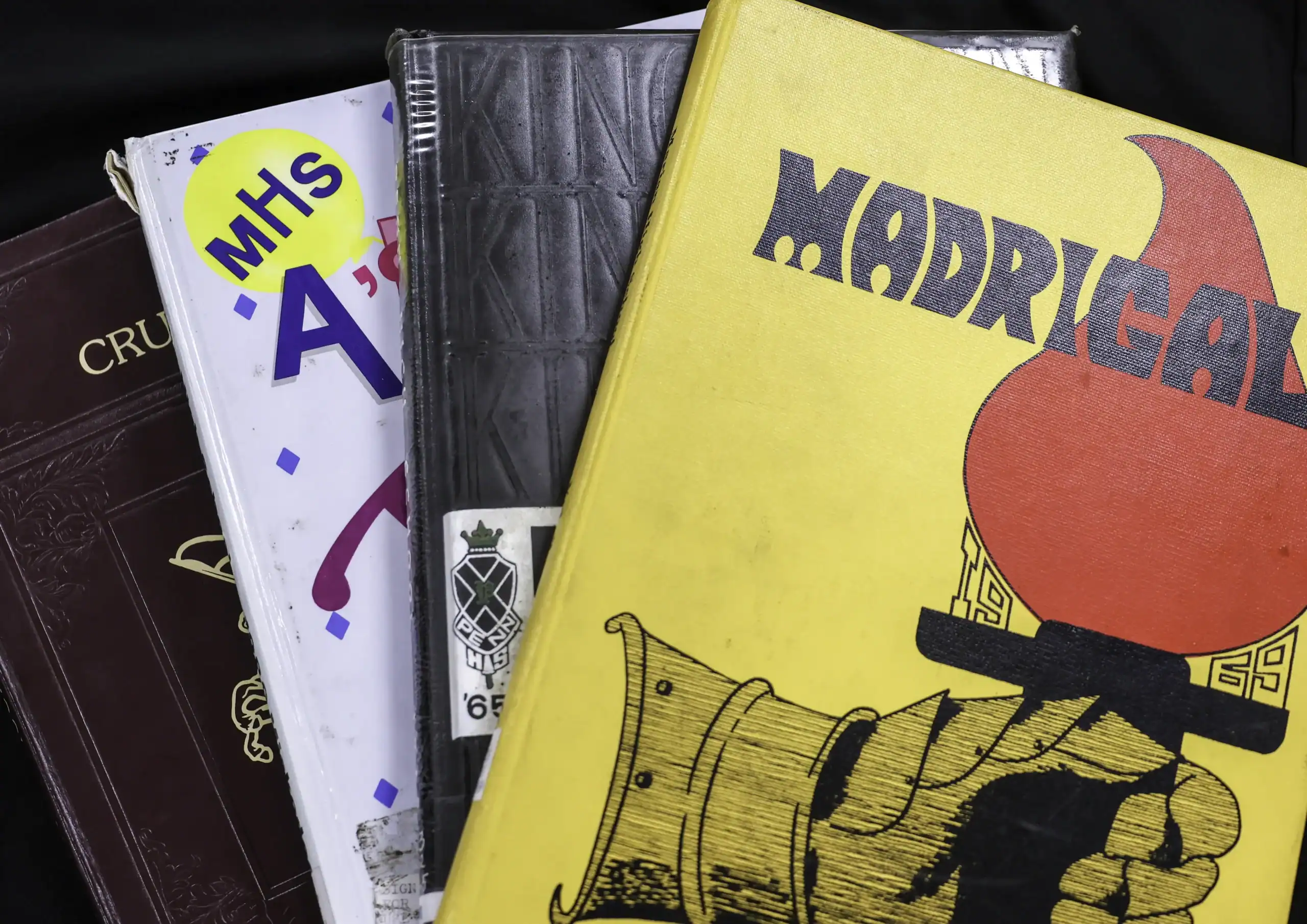 A pile of the yearbooks named Madrigal for Marian High School, Bittersweet for Penn High School, Miscodeed for Mishawaka High School and Madisonian from the former Madison Township School in Wakarusa.