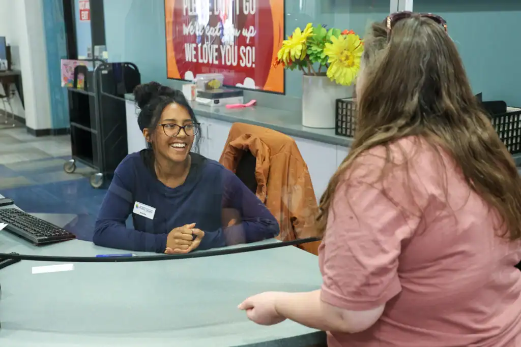 A staff member helping patrons at the Youth Service desk at the Mishawaka Library.